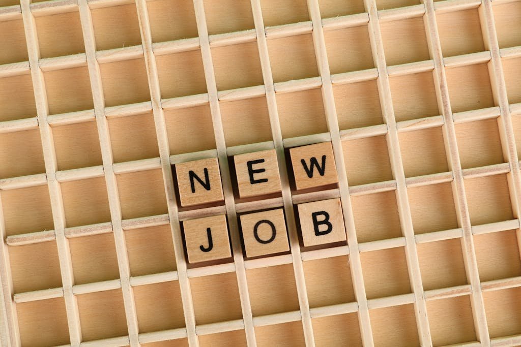 wooden letter tiles spelling 'NEW JOB' on a grid.